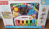 Boxed Fisher-Price Deluxe Kick & Play Piano Gym with multicolor features shown from the front