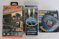 Photo of the dashboard camera in its box with the suction mount displayed, alongside the LED flowing USB-C to USB charging cable in packaging and the Car Vibez interior light strip in original packaging.