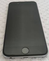 Front view of the iPhone 6s showing black screen with home button, slightly reflective surface.
