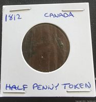 Front side of the 1812 Canada half penny token coin in white flip holder with handwritten notations.