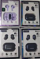 Front view of four sets of Fisher brand true wireless Bluetooth earbuds in original packaging: one purple set and three black sets with charging cases.