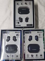 Photo showing three retail boxed sets of Fisher Rival Sound True Wireless Earbuds in black, with visible Fisher branding and product image on front of cases.