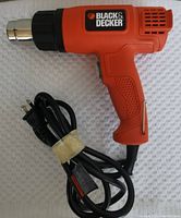 Black & Decker heat gun with attached power cord, top view showing side with branding and metallic nozzle.