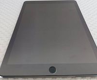 Front view of the Apple iPad showing the cracked and scratched screen with black display and Home button.