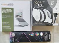 All items in original packaging showing some storage wear: laptop stand, foldable headphones, and RGB mouse pad.