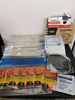 Overview photo showing multiple health-related items including hand warmers, face shields, disposable masks, and gauze sponges.