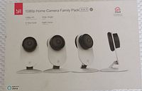 Front of the sealed box showing product details, branding, and image of four cameras.