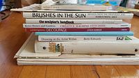 Stack of assorted art reference books including titles on decoupage, drawing, and painting.