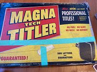 Photo of the original Magna Tech Titler box with product label and bright yellow, red and black design; vintage lettering set for creating professional titles.