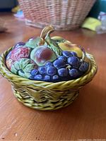 Side view showing the basket weave design on the dish and vibrant hand-painted fruit on the lid