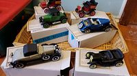 7 vintage die cast collector model cars displayed on original white boxes with certificates of authenticity