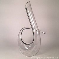 Full view of contemporary clear glass spiral decanter with black stripe showing its unique loop and elongated spout shape.