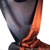 Full view of the fabric showing the copper satin finish side and the indigo side with copper flecks draped together.
