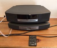 Front view of Bose Wave Music System stacked on 5-disc CD changer with remote on top