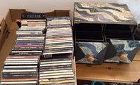 Photo showing a large stack of music CDs alongside a decorative storage box with drawers