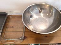 Metal non-stick baking pan and Pyrex glass casserole dish on a wooden surface