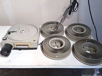 Kodak slide projector with four empty slide carousels, showing full lot