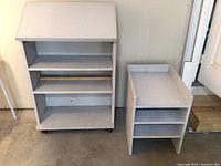 Front view of painted wooden podium on wheels and smaller shelving unit side by side.