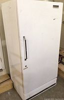 Full view of the exterior of the white Sears upright freezer showing the entire unit and door with handle.
