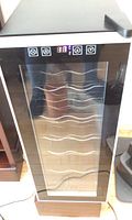 Front view of SPT wine fridge showing glass door with digital temperature display and control panel on the top.