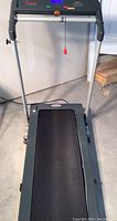 Full view of Sunny treadmill with folded frame and visible running belt.