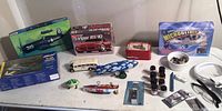Photo showing the assortment of vintage model airplane and car kits, Microblimp, small metal toys, model paint, and accessories spread on a surface.