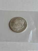 Obverse side of 1885 Morgan Silver Dollar coin showing Lady Liberty and date.