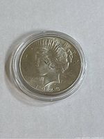 Obverse side of 1923 Liberty Silver Peace Dollar coin showing Lady Liberty in profile with date 1923, in a clear protective case.