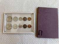 Overview photo showing the full 1958 US proof set in clear plastic display case next to textured purple outer cover.