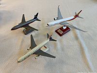 Three model airplanes on a surface, showing size and condition.