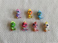 Group of 7 colorful Littlest Pet Shop bird figurines shown together on a textured surface.
