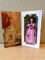 Barbie doll in pink gown inside original decorated box with Valentine-themed backdrop