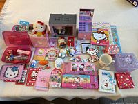 Overall lot showing all items spread on table including plush, stationery sets, containers, toys, and mug