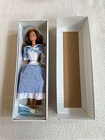 Photo of Little Debbie Barbie doll in original box wearing blue gingham dress with silver bodice.
