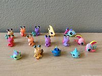 Front view of the 15 Littlest Pet Shop ocean creature figures arranged in rows on a gray surface against a neutral background, showing hermit crabs and fish with large eyes and colorful designs.