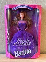 Front view of Special Edition Purple Passion Barbie doll in original box showing doll in purple sparkling gown with feathered hair accessory and black choker.