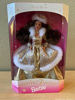Front view of Special Edition Winter Fantasy Barbie doll in gold dress with white faux fur trim, inside intact original box.
