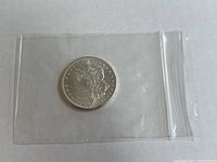 Obverse side of the 1885 Morgan silver dollar coin showing Liberty's profile.