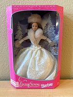 Front view of the Winter Evening Barbie Doll in original pink box showing doll in white fur-trimmed gown and hat