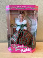 Front view of Winter's Eve Barbie doll in original packaging dressed in holiday plaid gown.