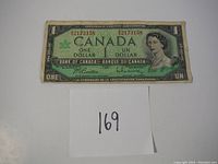 Front side of 1967 Canadian one dollar banknote showing Queen Elizabeth II and serial number 2173158.