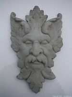 Front view of cement Green Man face wall decor showing detailed leaf and facial design