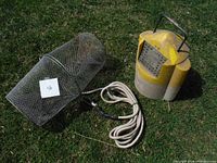 Photo showing both the minnow trap and yellow live bait bucket placed on grass. The trap is a metal wire mesh cylinder with attached rope. The bucket is plastic with ventilation holes and a handle.