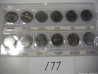 Complete set of twelve Canadian quarters from 1992 in a clear plastic holder showing each coin associated with a month and province or territory.