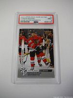 Front image of card showing Connor Bedard in Chicago Blackhawks uniform with grading label PSA 9 Mint