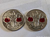Two Canadian quarters with red Remembrance Poppies and dated 1945-2010, representing the full lot contents.