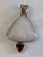 Front view of pendant highlighting raw jadeite stone and red stone at base