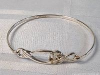 Front angle of sterling silver bracelet showing the decorative knot in the center.