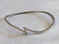 Full view of the sterling silver bracelet showing the open end design and polished finish.