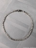 Full view of the 8-inch sterling silver bracelet laid flat on fabric background.